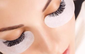 woman with undereye cosmetic pads and long thick eyelashes
