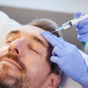 female beautician giving mature male patient botox injection in picture id1147972566 300x300